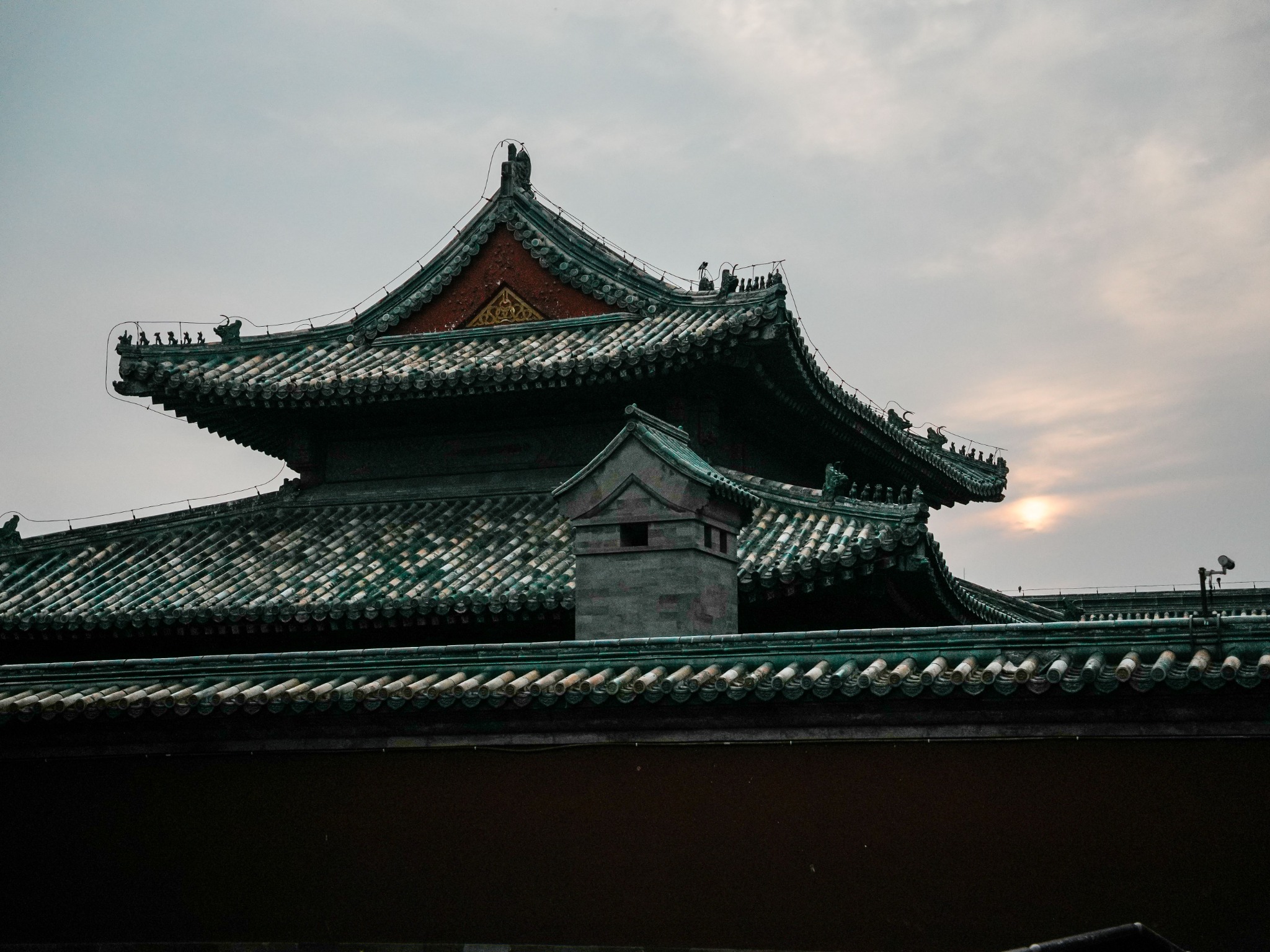 Traditional Beijing roofline beneath a quiet evening sky