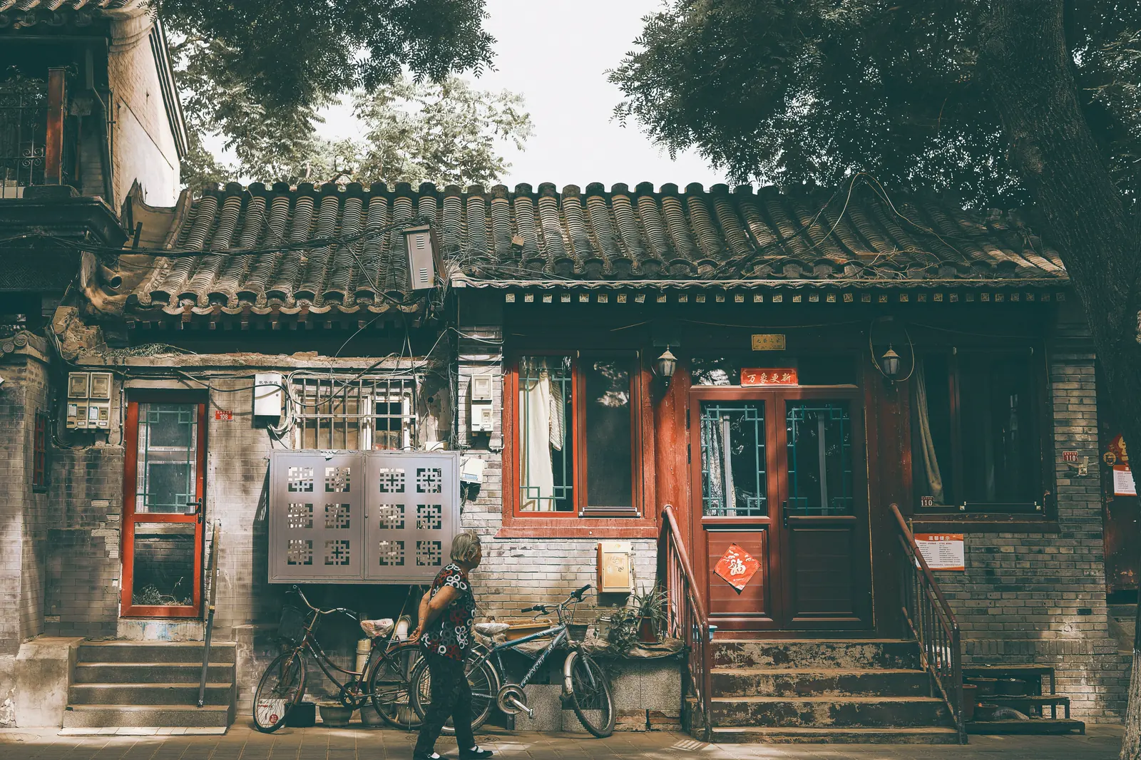 A bicycle parked outside a traditional courtyard doorway