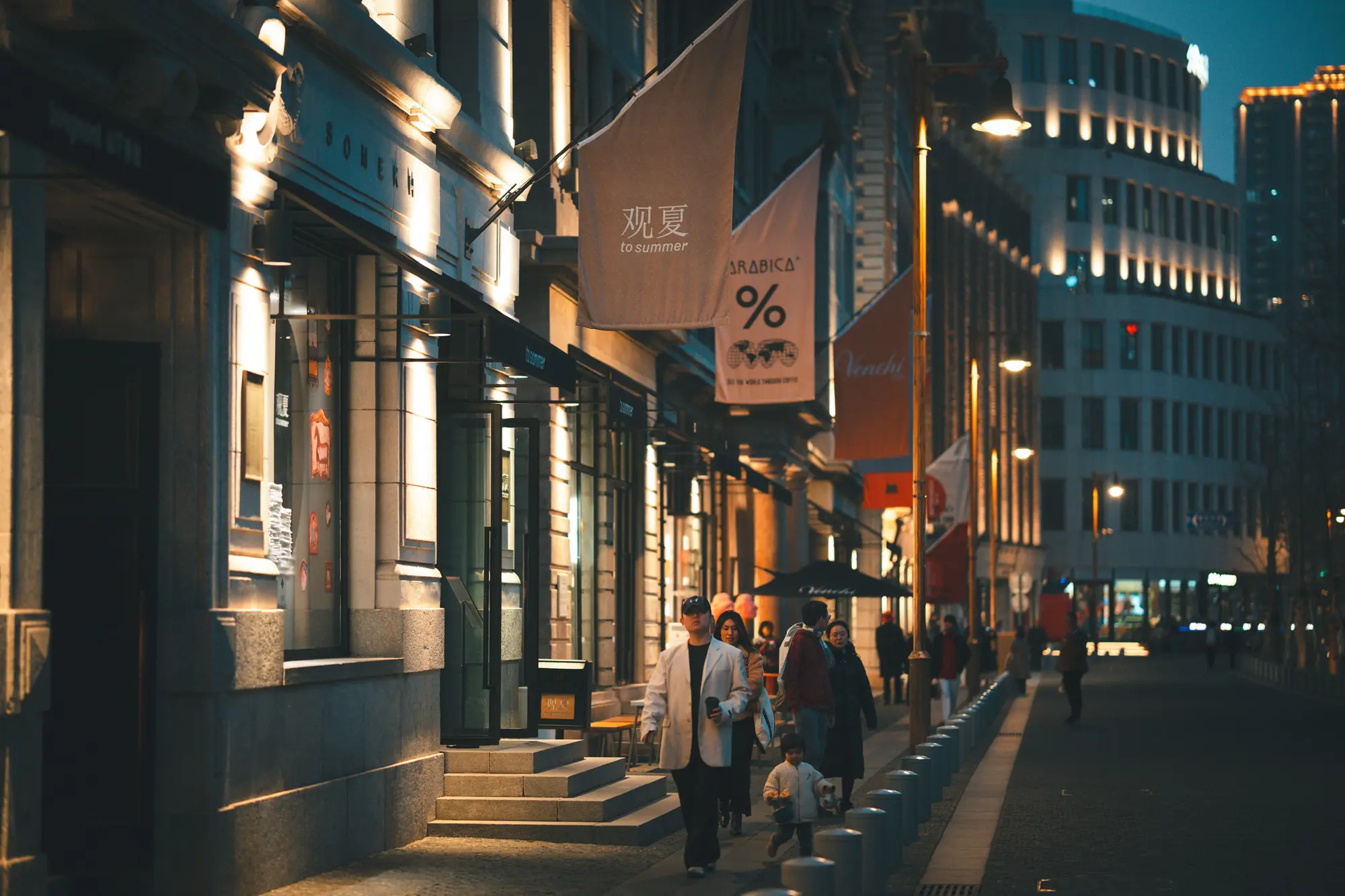 A lively Shanghai side street at night beneath warm shop lights