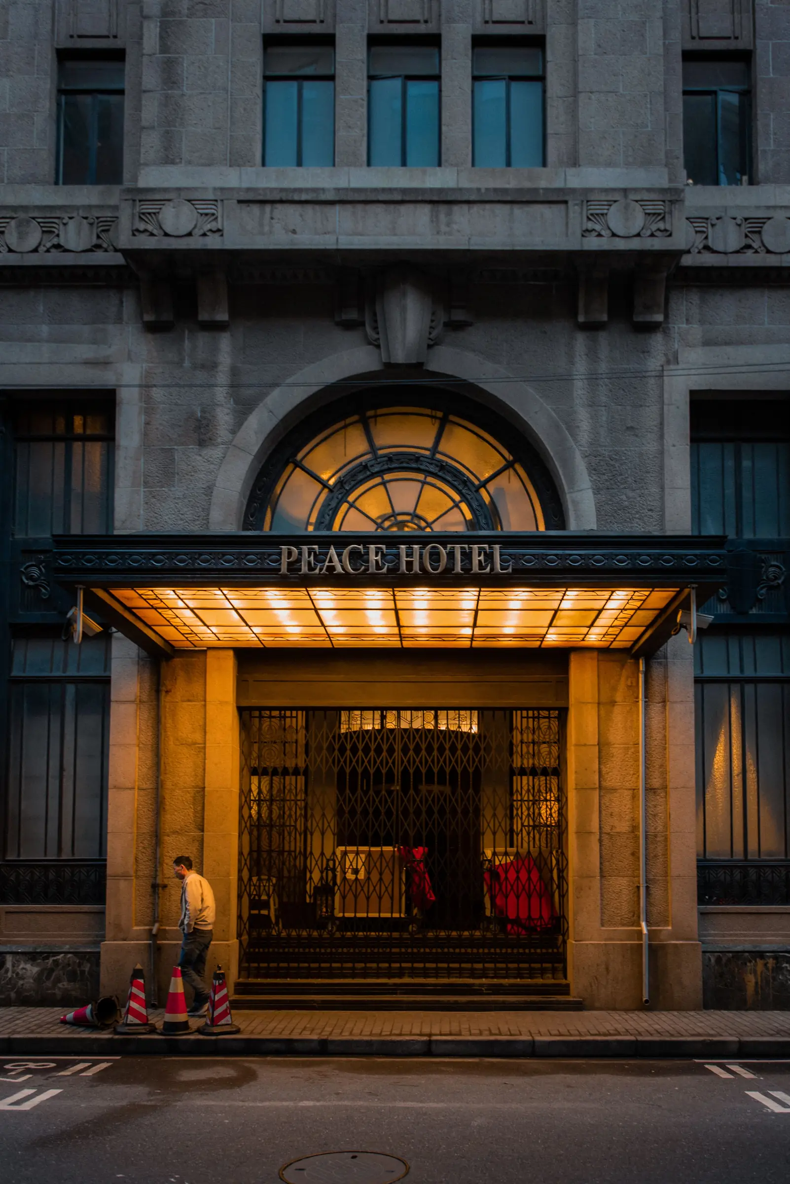 The Peace Hotel entrance glowing at night on Shanghai’s Bund