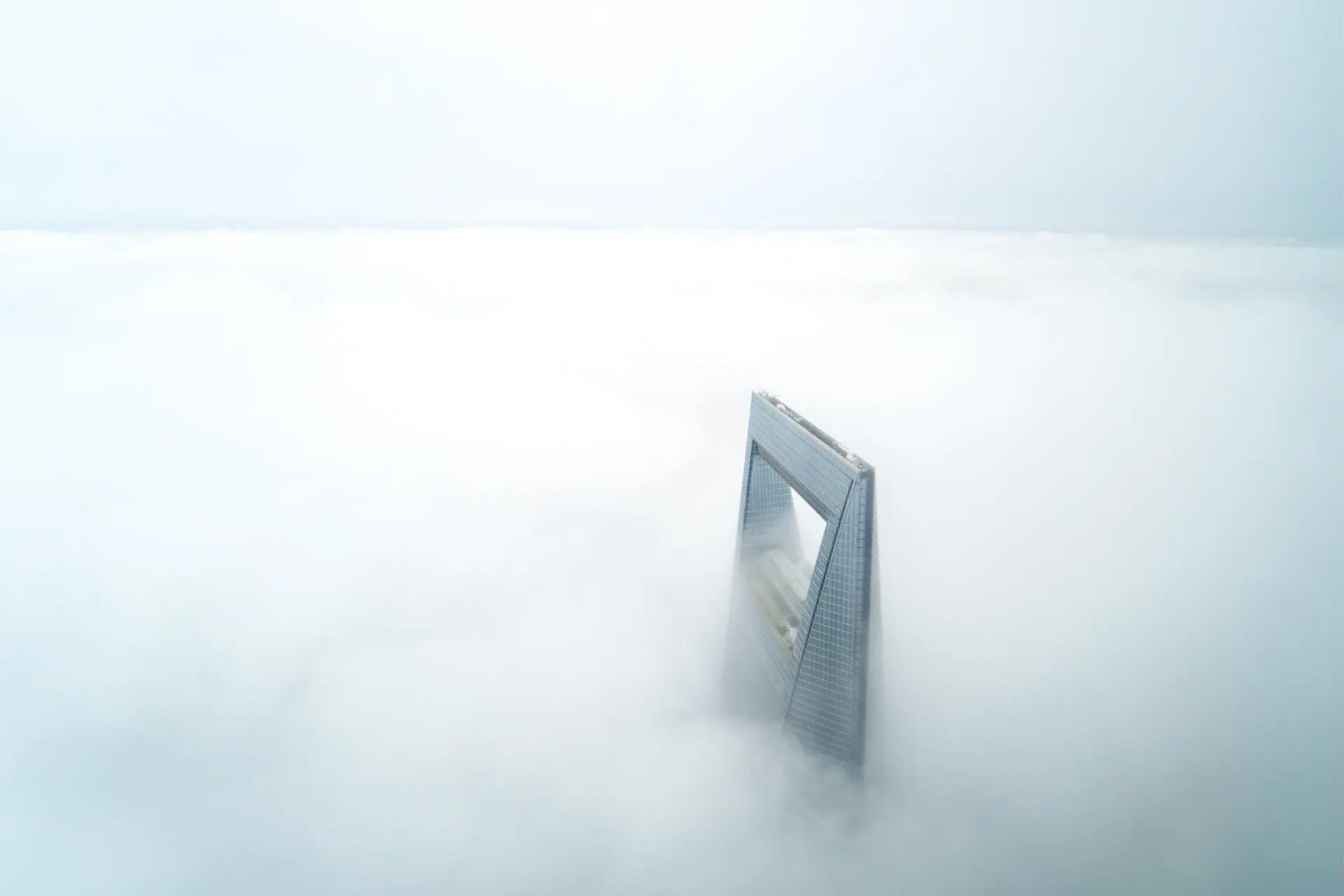 Shanghai World Financial Center rising through low cloud in Pudong