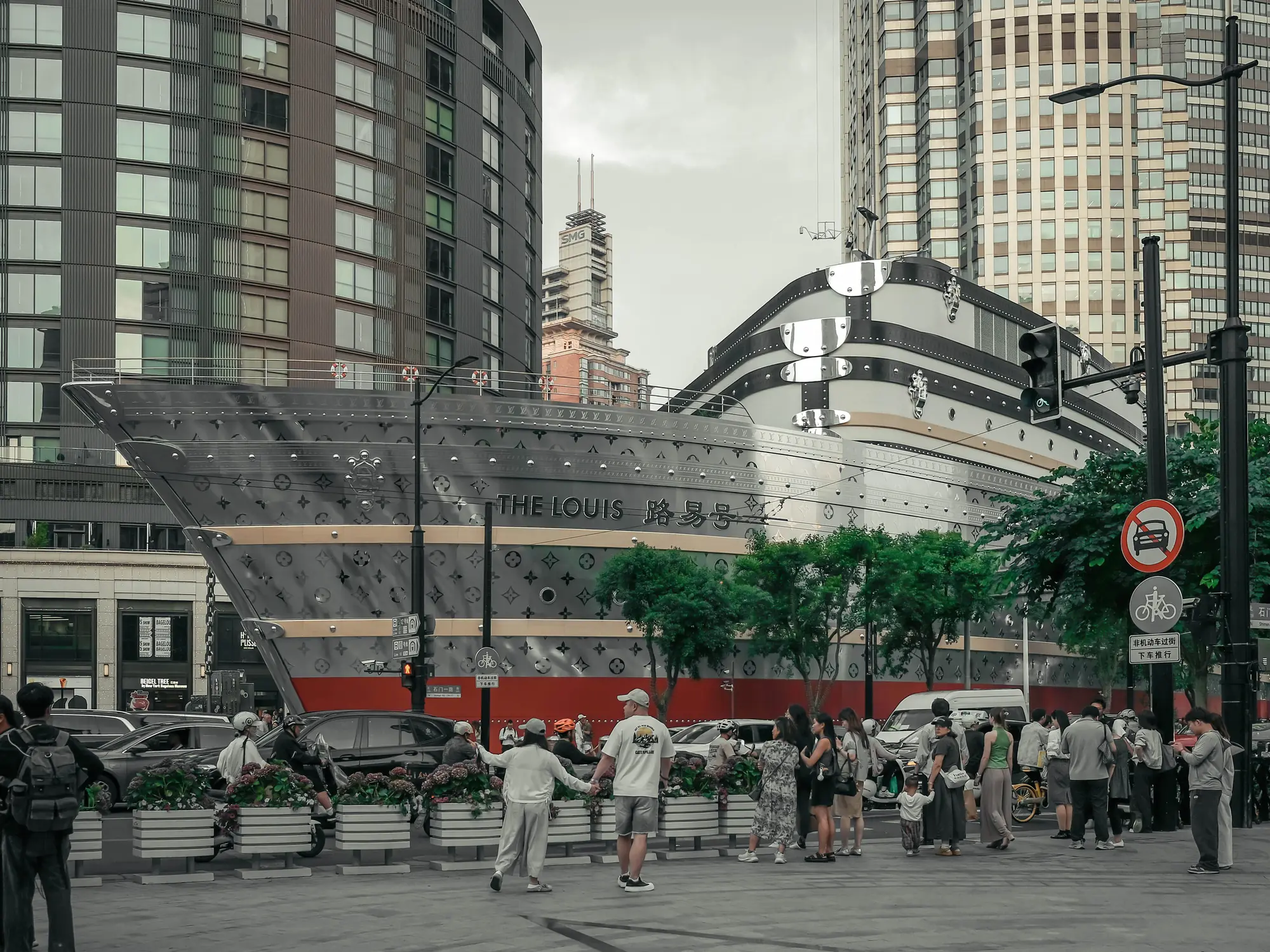 A long silver building in Shanghai shaped like a ship above the street