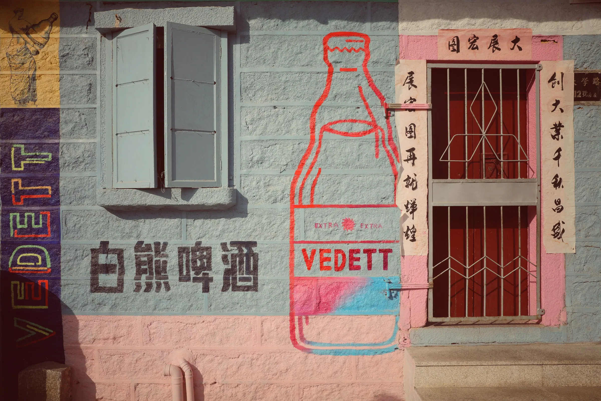 Painted lettering, shutters and worn plaster on an old Xiamen wall