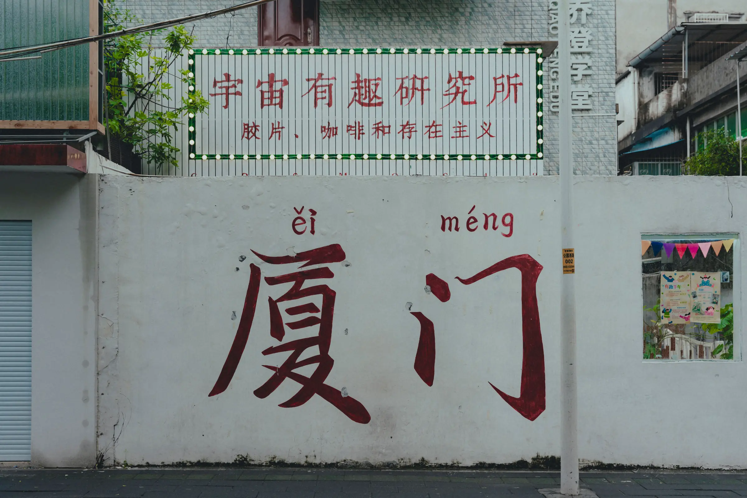 The large Chinese characters for Xiamen painted across a street wall