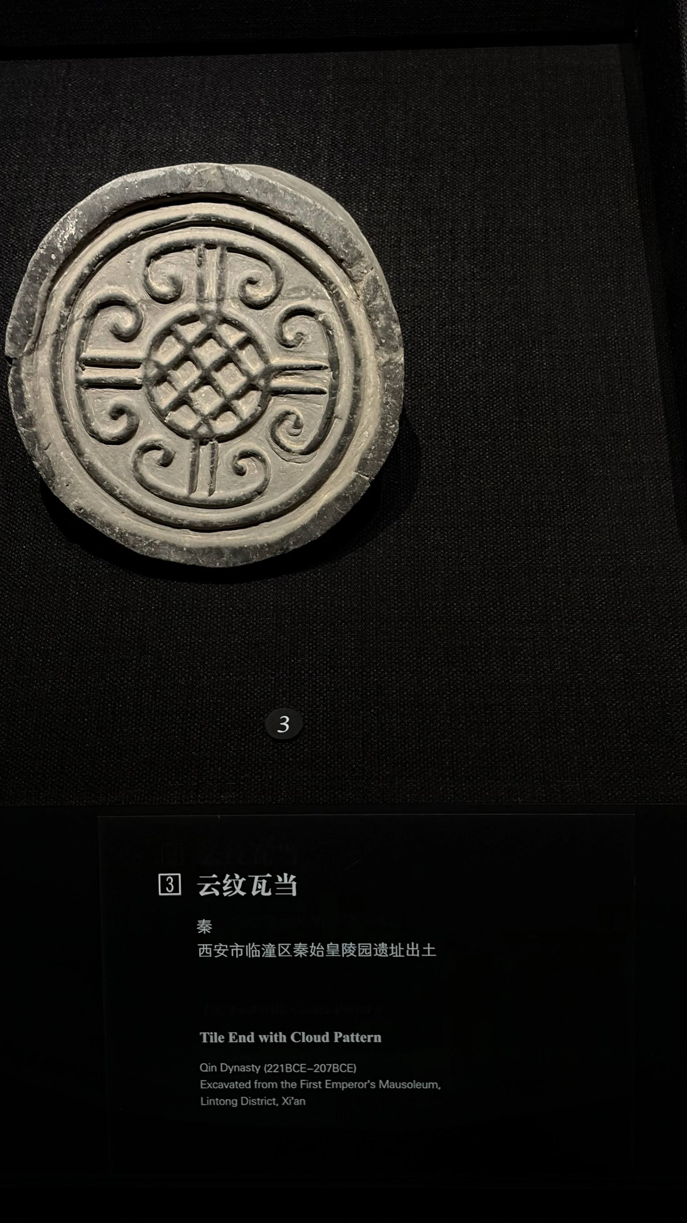 A circular Qin dynasty tile end decorated with a cloud pattern