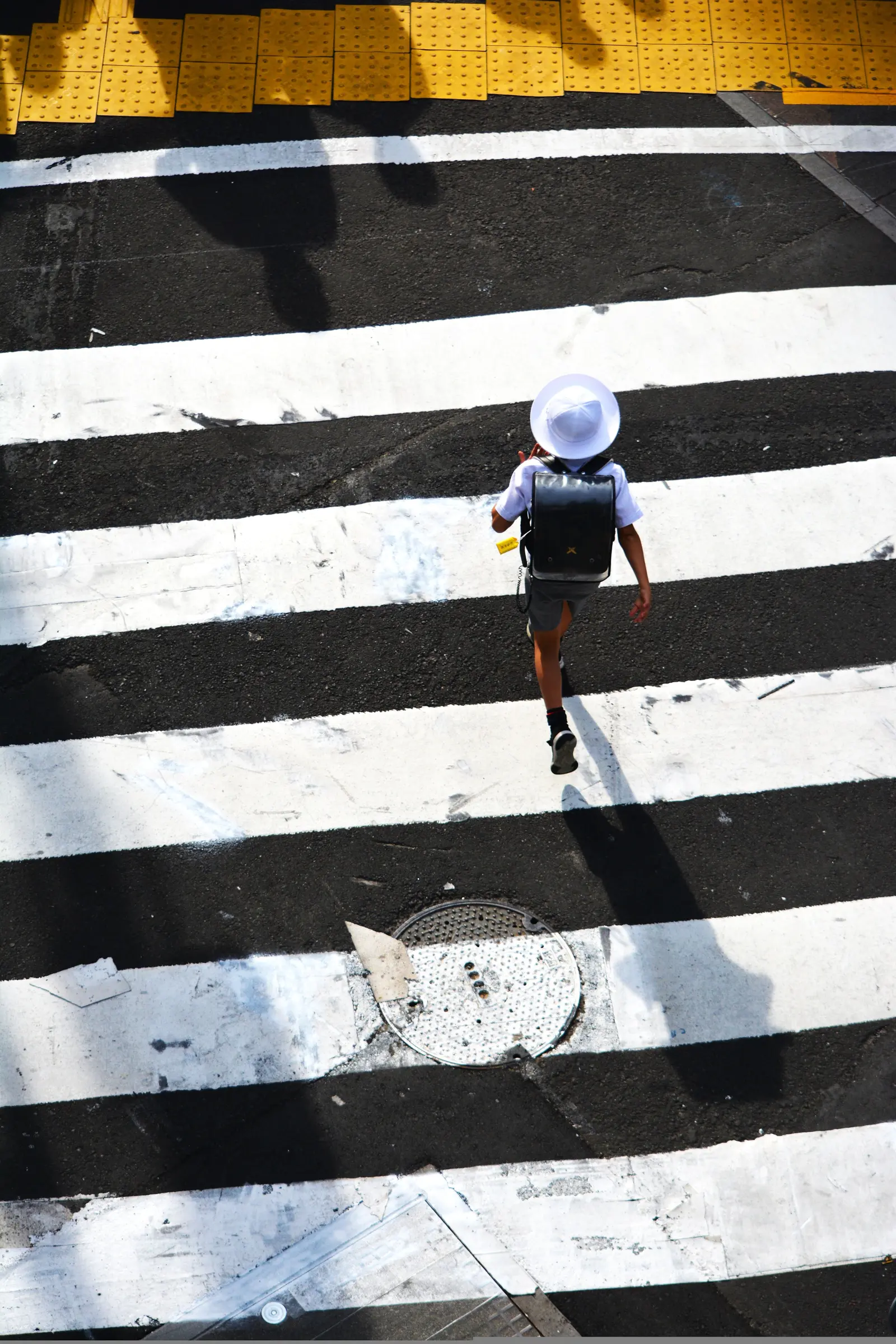 A pedestrian crossing a graphic black-and-white street