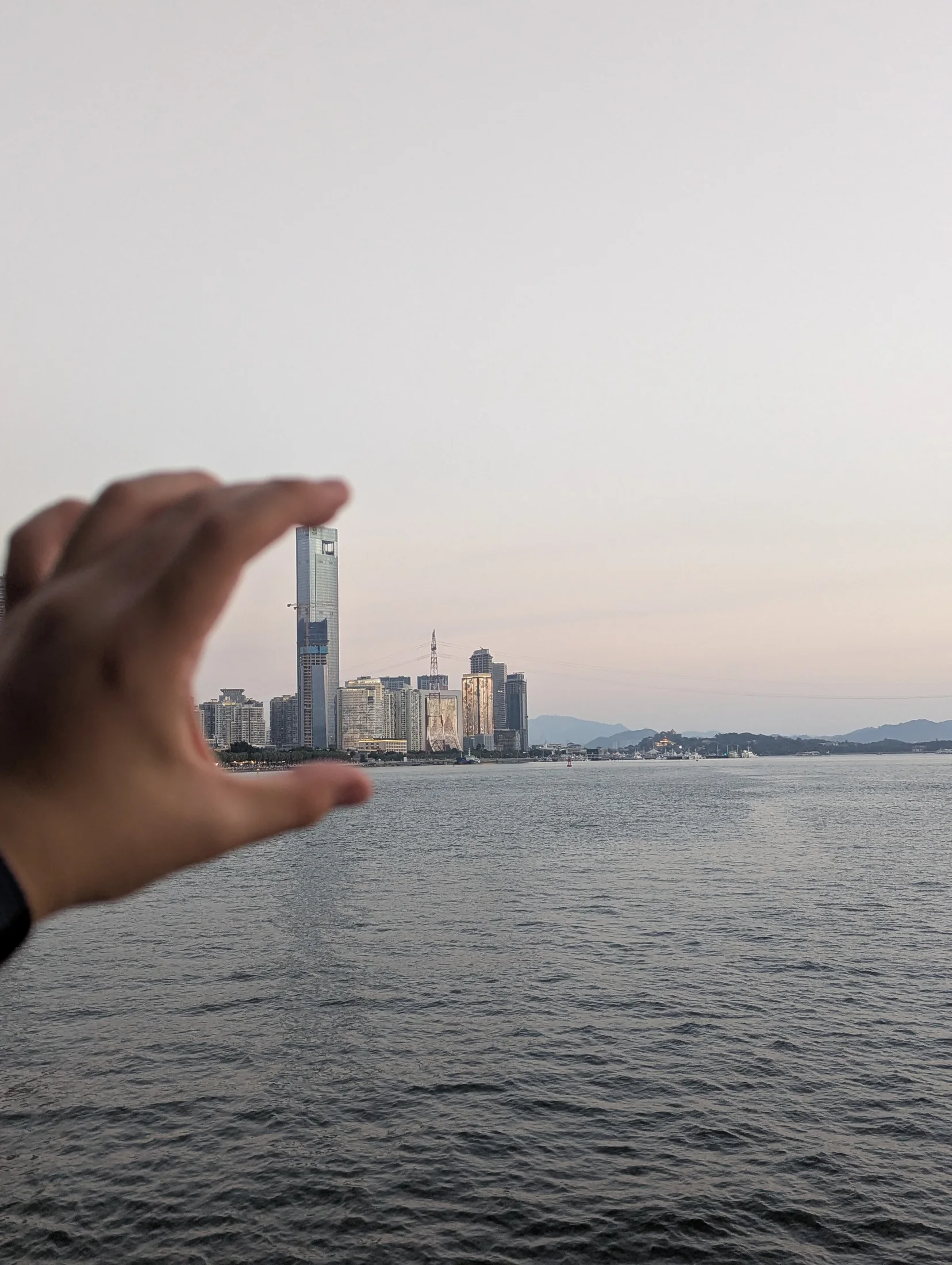 傍晚海面与远处城市天际线